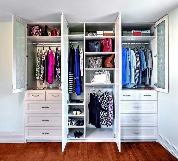 Custom built wardrobe closet with clothing items neatly hung and oragnized